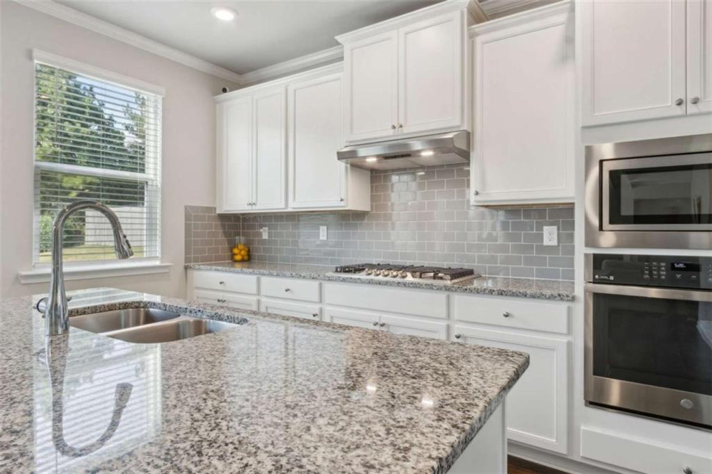429 Paxton Lane Jefferson, GA 30549 - Photo 25 of 53 a kitchen with granite countertop a sink a stove and cabinets