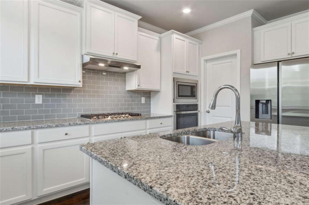 429 Paxton Lane Jefferson, GA 30549 - Photo 26 of 53 a kitchen with granite countertop a stove a sink and a microwave