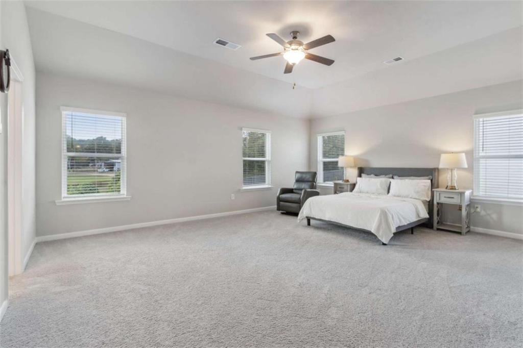 429 Paxton Lane Jefferson, GA 30549 - Photo 31 of 53 a spacious bedroom with a bed and a chandelier