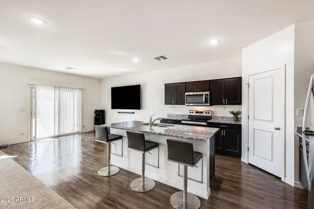 a view of a living room a flat screen tv and kitchen view