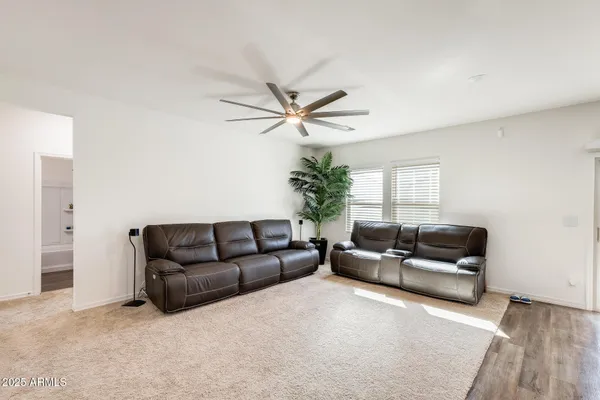 a open kitchen with stainless steel appliances kitchen island granite countertop a stove top oven a sink dishwasher and a refrigerator with wooden floor