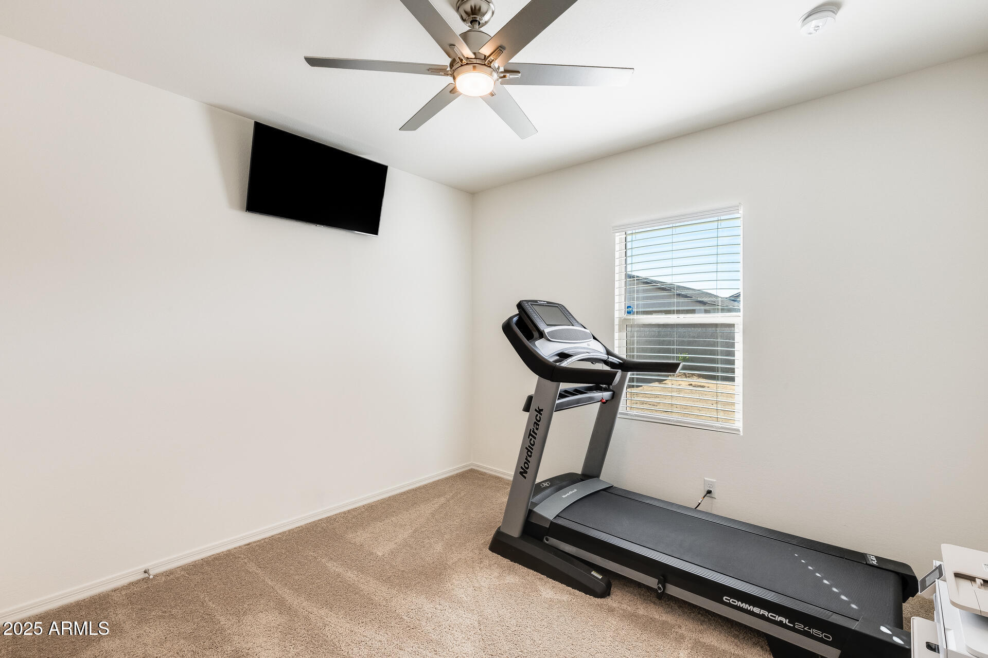 5663 East Moira Road Florence, AZ 85132 - Photo 17 of 37 a room with gym equipment and a flat screen tv