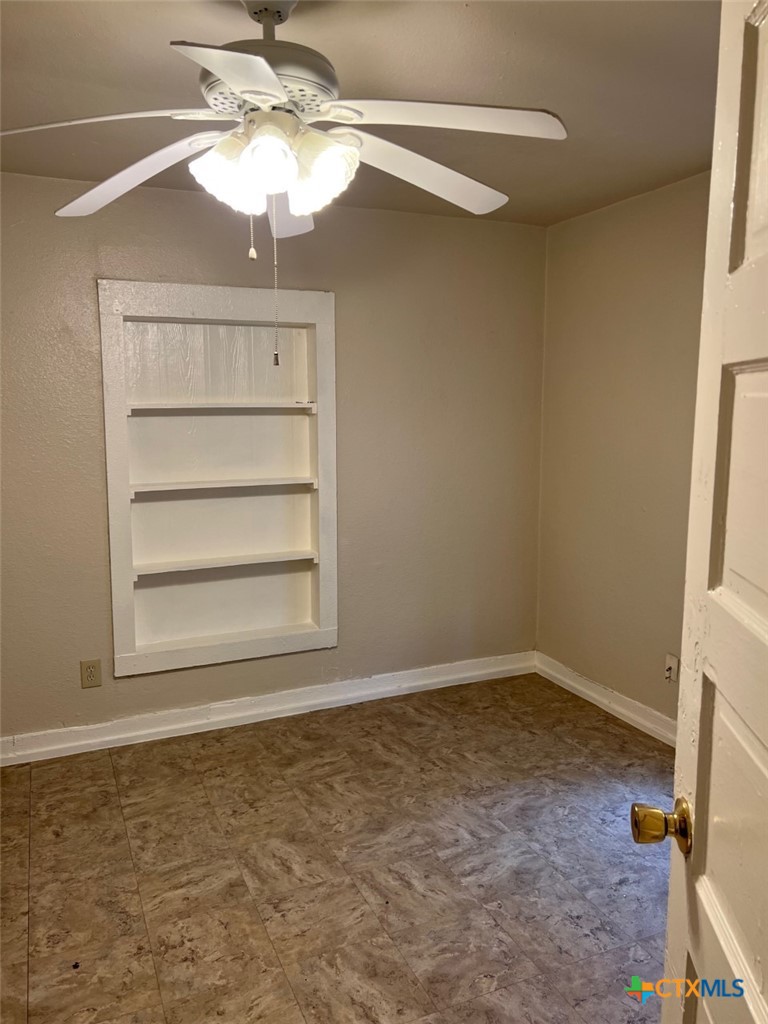 225 Lamar Street Luling, TX 78648 - Photo 11 of 12 en empty room with a window and ceiling fan