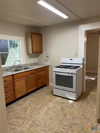 a kitchen with granite countertop a stove a sink and a granite counter tops