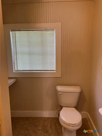 a white toilet sitting next to a window