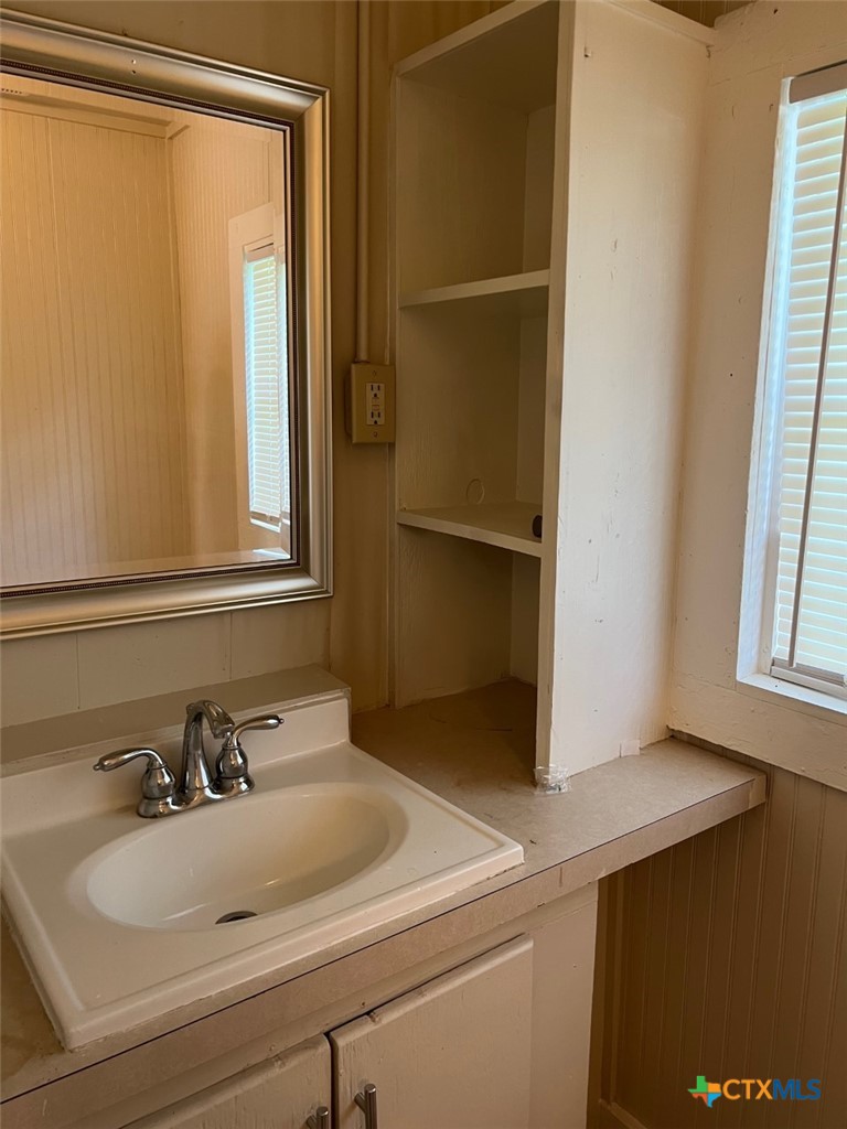 225 Lamar Street Luling, TX 78648 - Photo 10 of 12 a bathroom with a sink and a mirror