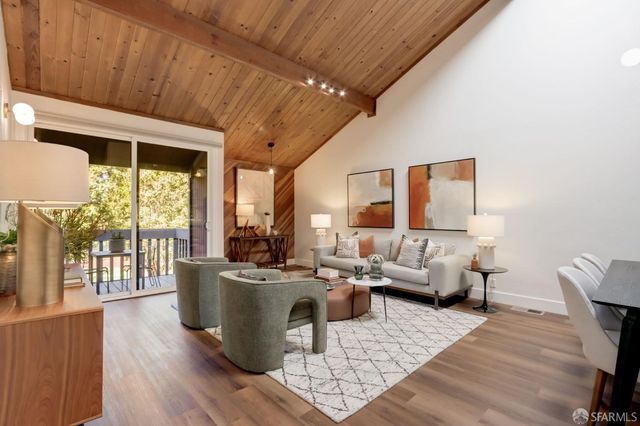 a living room with furniture wooden floor and a large window