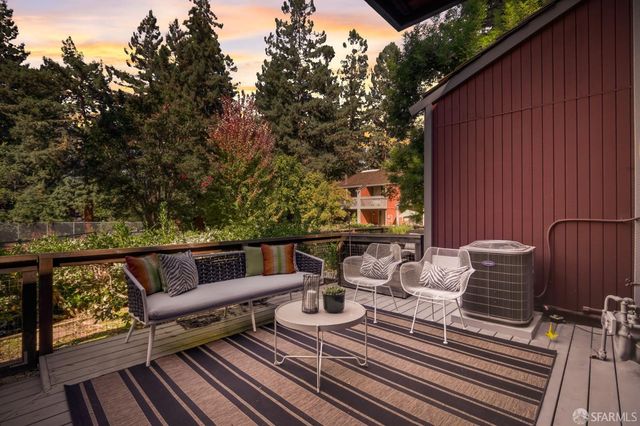a roof deck with couches and wooden floor
