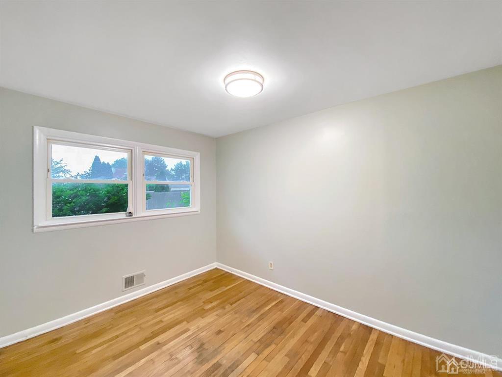 15 Racetrack Road East Brunswick, NJ 08816 - Photo 10 of 13 a view of empty room with wooden floor and fan