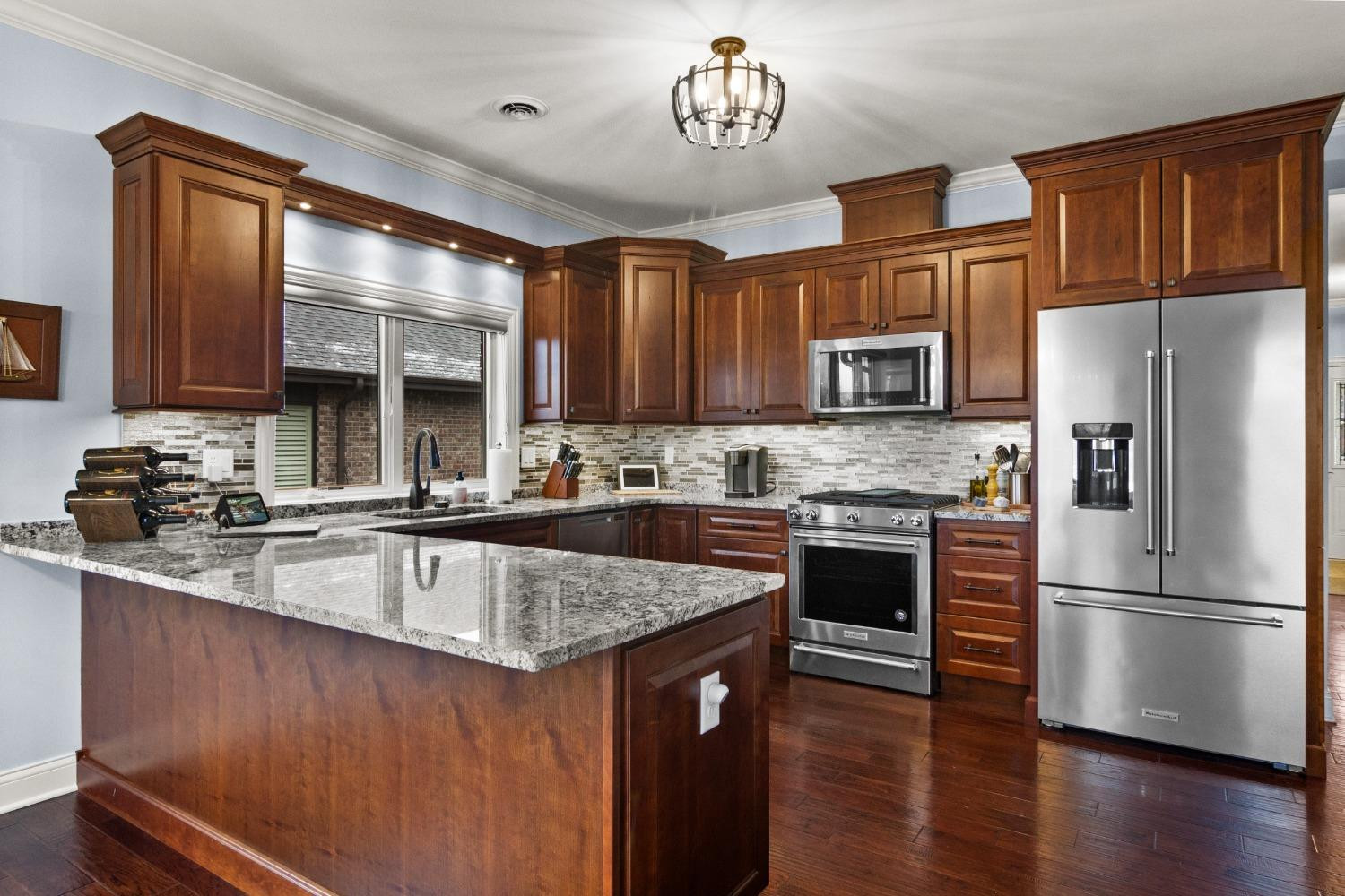 8415 Dancing Waters Lane St. John, IN 46373 - Photo 14 of 31 a kitchen with stainless steel appliances granite countertop a refrigerator a stove top oven a sink and dishwasher with wooden floor