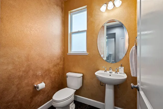 a bathroom with a toilet sink and mirror