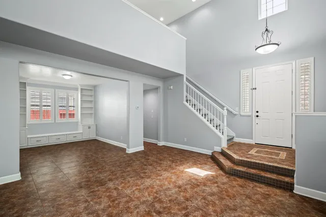 a view of an empty room with stairs and a window