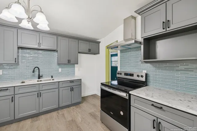 a kitchen with stainless steel appliances granite countertop a sink stove and cabinets