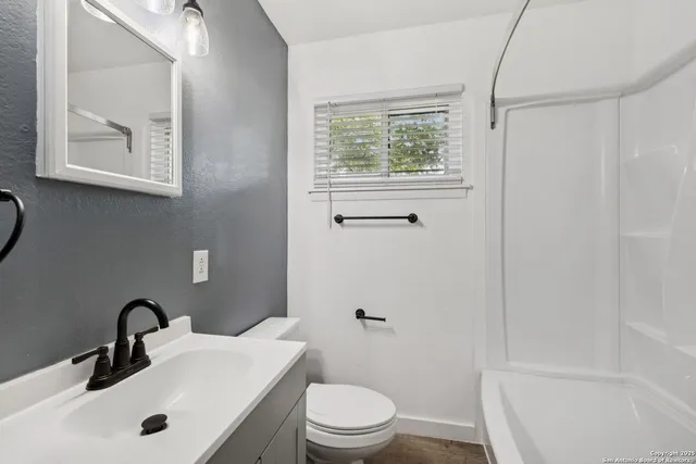 a bathroom with a sink toilet and a mirror