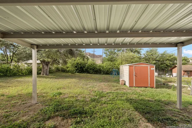 a backyard of a house with a yard and outdoor seating