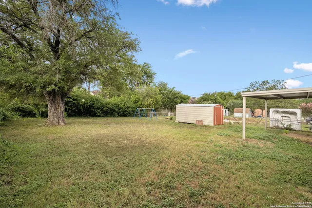 a backyard of a house with table and chairs