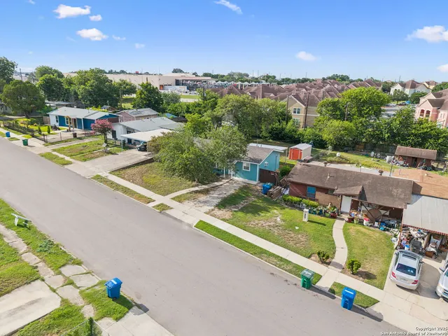 an aerial view of a house with a garden and houses