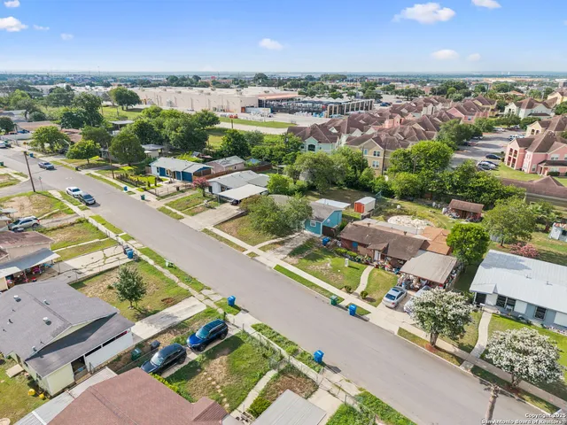 an aerial view of a city with lots of residential buildings and mountain view in back