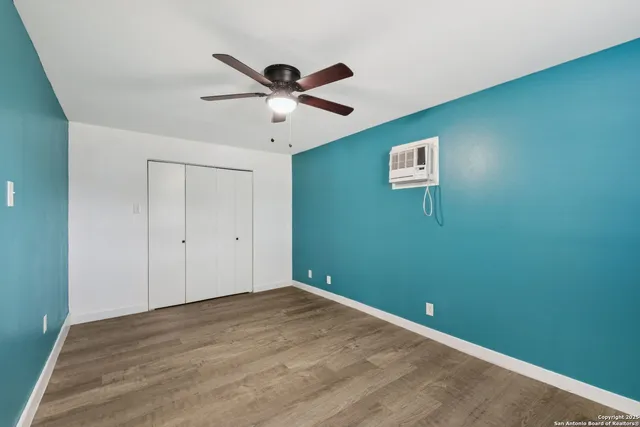 a view of a big room with wooden floor and windows