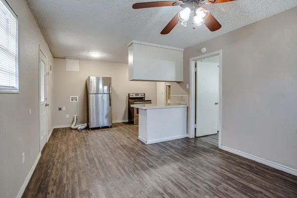 a view of a kitchen with a sink refrigerator and wooden floor