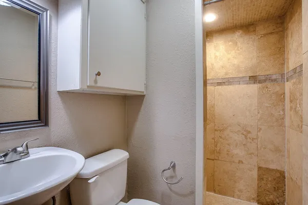 a bathroom with a toilet a sink and shower