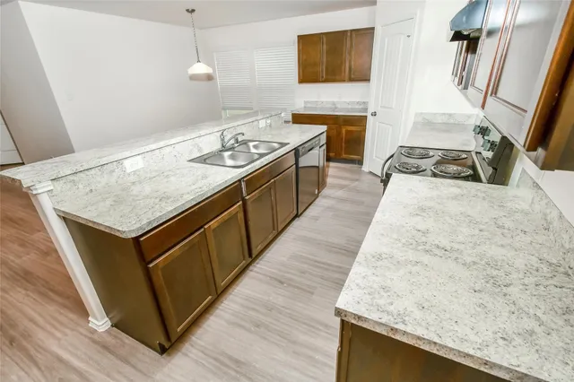 a kitchen with granite countertop a stove and a wooden floor