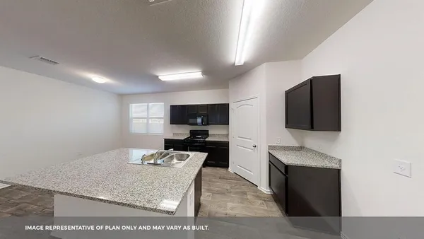 a large kitchen with stainless steel appliances kitchen island granite countertop a refrigerator and a sink