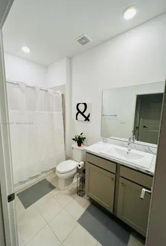 a bathroom with a double vanity sink toilet and shower