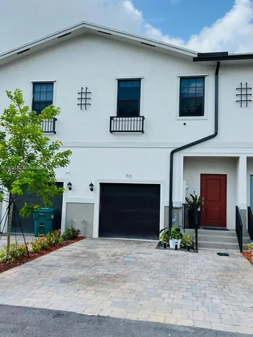 a front view of a house with a yard and a garage