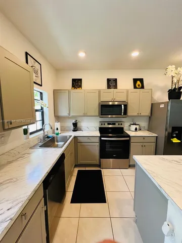 a kitchen with a sink a stove and cabinets