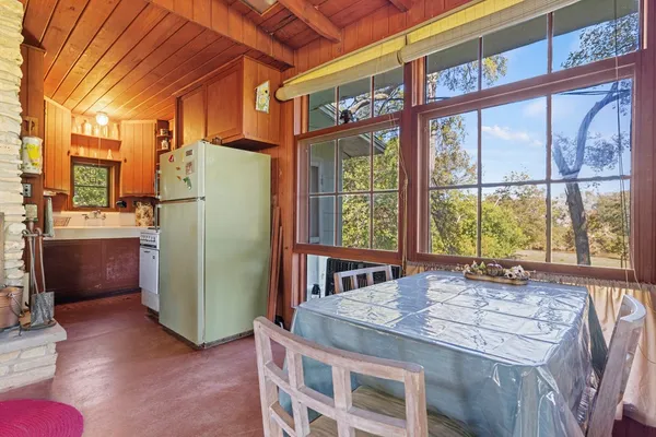 a dining room with a large window and a refrigerator