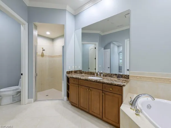 a bathroom with a granite countertop sink mirror and toilet
