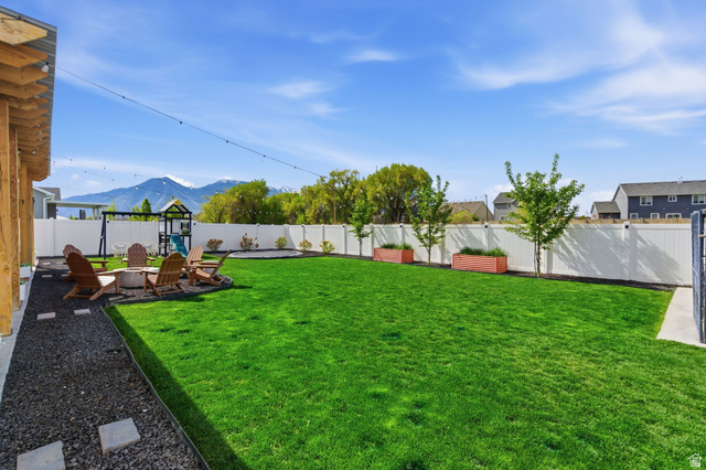 596 South Meade Street Mapleton, UT 84664 - Photo 34 of 38 Fenced backyard with a patio area, a fire pit, and a mountain view
