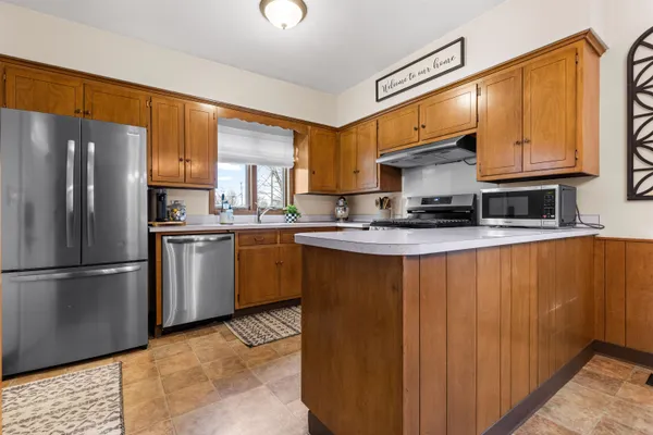 a kitchen with stainless steel appliances granite countertop a refrigerator sink and cabinets