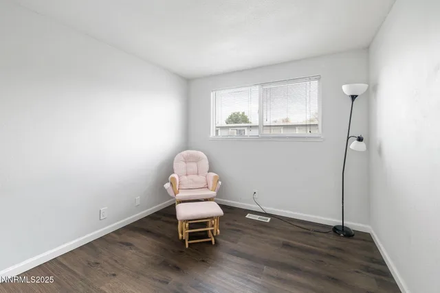 a view of a room with wooden floor lounge chair and windows