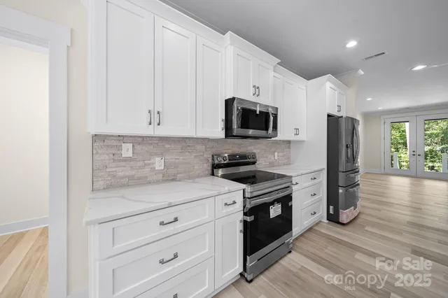 a kitchen with stainless steel appliances granite countertop a stove a sink and a refrigerator