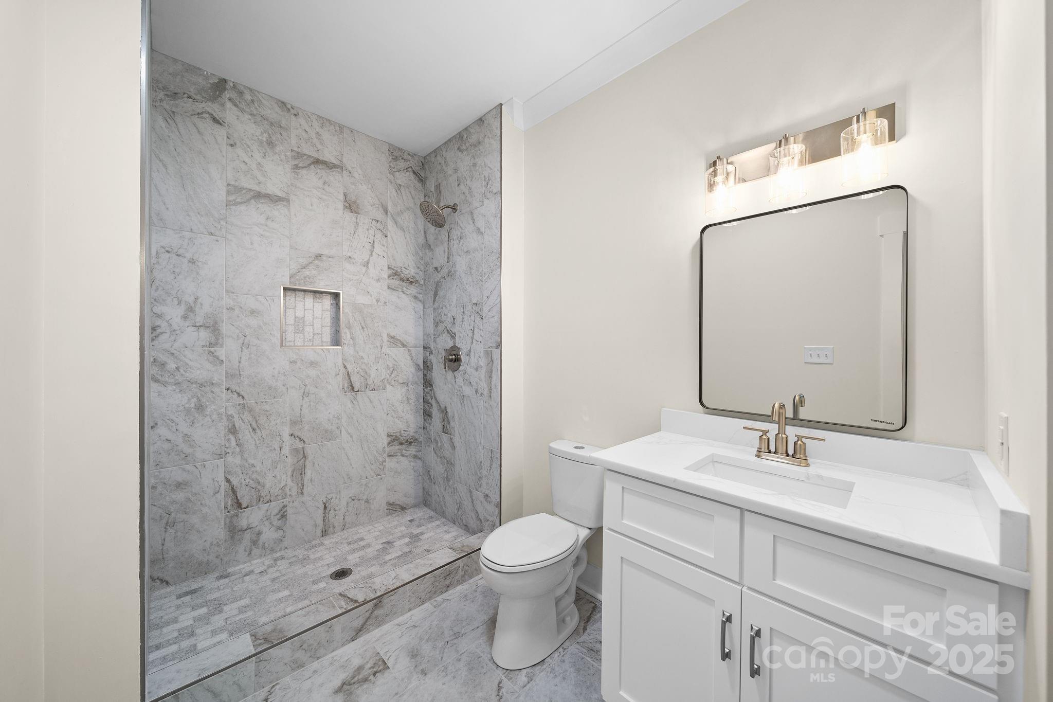 4460 R R L Lane Midland, NC 28107 - Photo 39 of 48 a bathroom with a granite countertop sink a toilet and shower