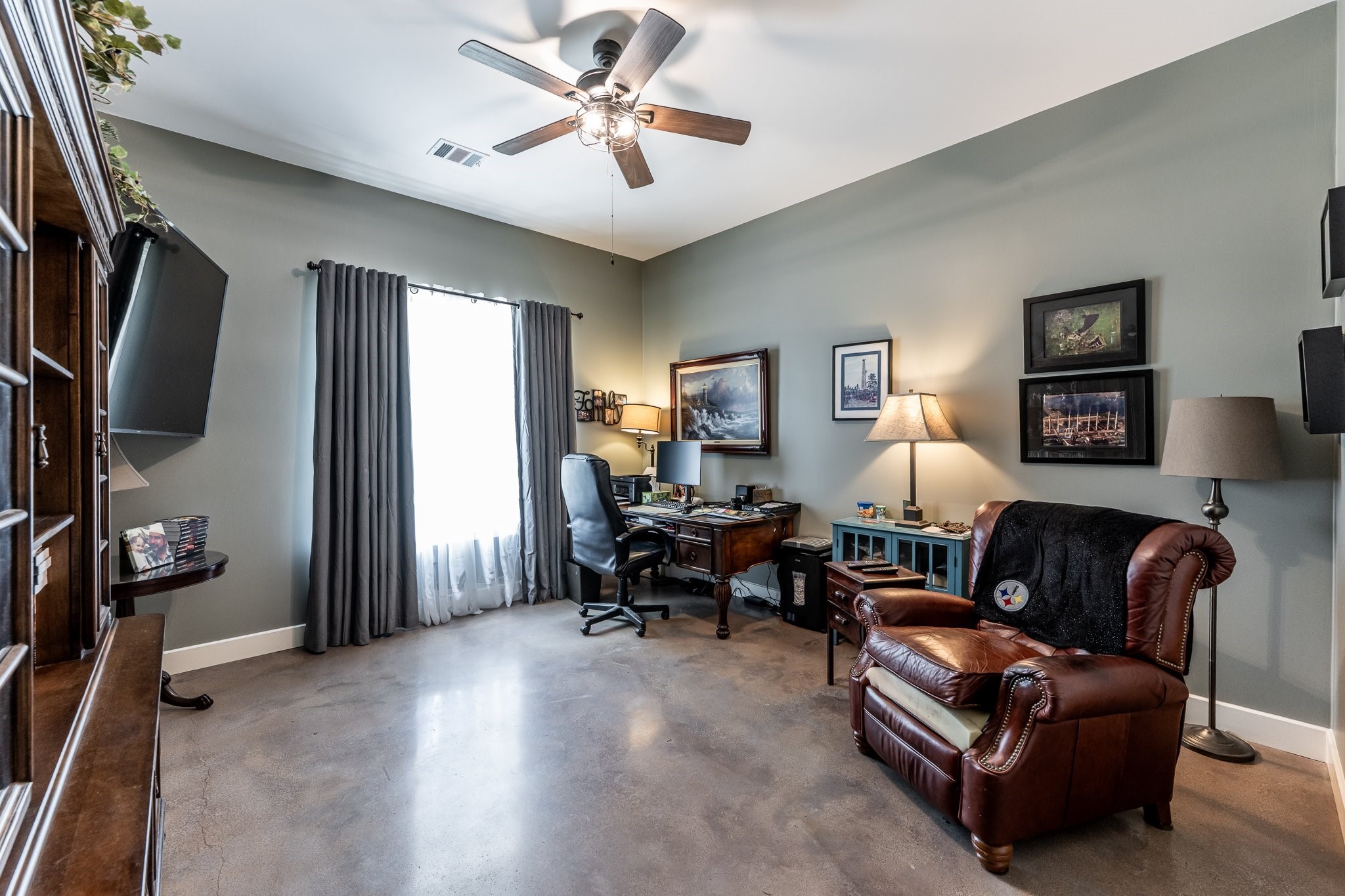 13334 Fultz Road Conroe, TX 77304 - Photo 18 of 49 Currently styled as a home office, this versatile bedroom features stained concrete floors and plenty of natural light—perfect for work or guests.