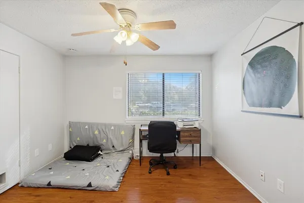 a view of a workspace with furniture and a window