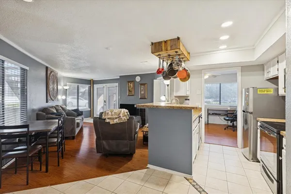 a living room filled with furniture and kitchen view