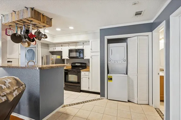 a kitchen with stainless steel appliances kitchen island granite countertop a refrigerator and a sink