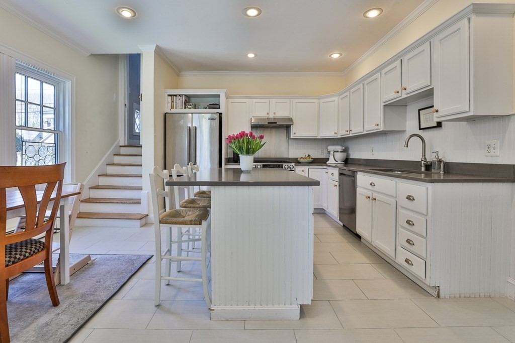 27 Walnut Road Hamilton, MA 01982 - Photo 15 of 42 a kitchen with stainless steel appliances kitchen island granite countertop a stove a sink and a refrigerator