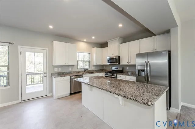 a large kitchen with stainless steel appliances granite countertop a stove a sink a refrigerator and a granite counter tops