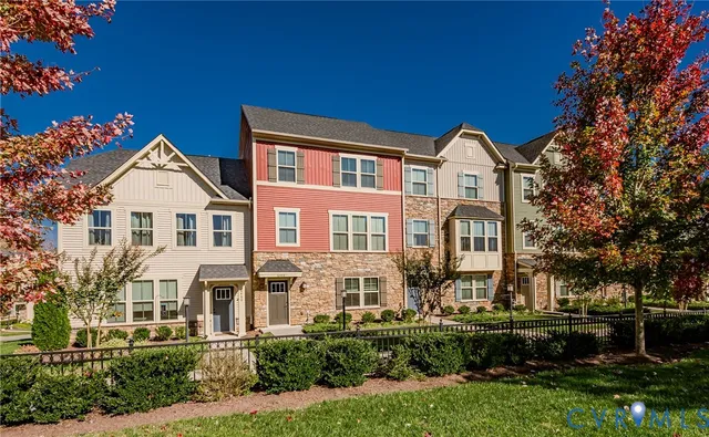 a front view of a residential houses with yard and green space
