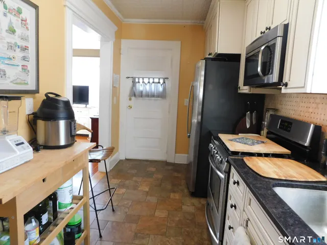 a kitchen with stainless steel appliances granite countertop a stove refrigerator and microwave