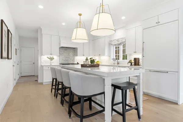 a kitchen with stainless steel appliances a dining table chairs stove and refrigerator