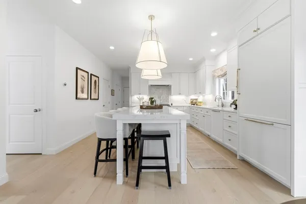 a kitchen with granite countertop white cabinets and stainless steel appliances