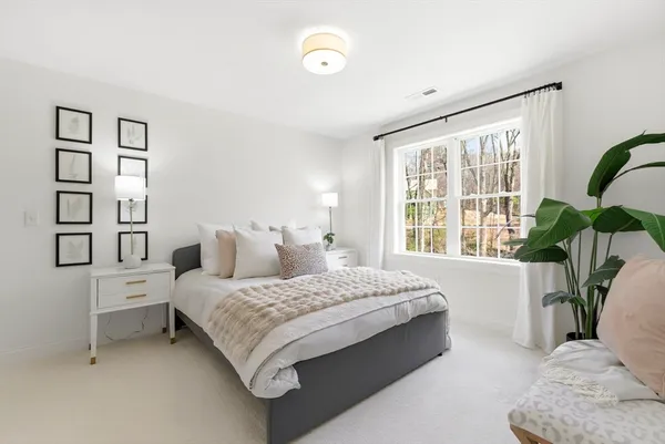 a bedroom with a bed and a large window