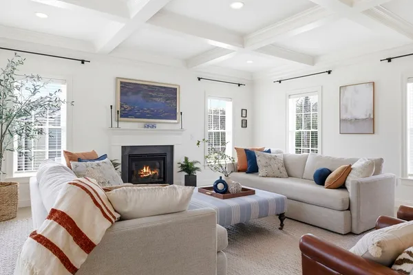 a living room with furniture a fireplace and windows