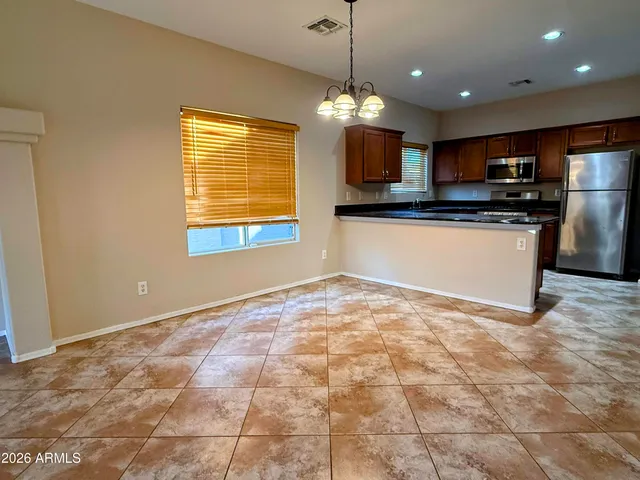 a view of a kitchen with granite countertop a stove top oven a sink a counter space and cabinets